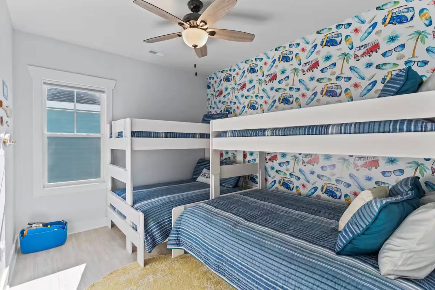 Bunk room with two sets of bunk beds and blue fish-pattern wallpaper