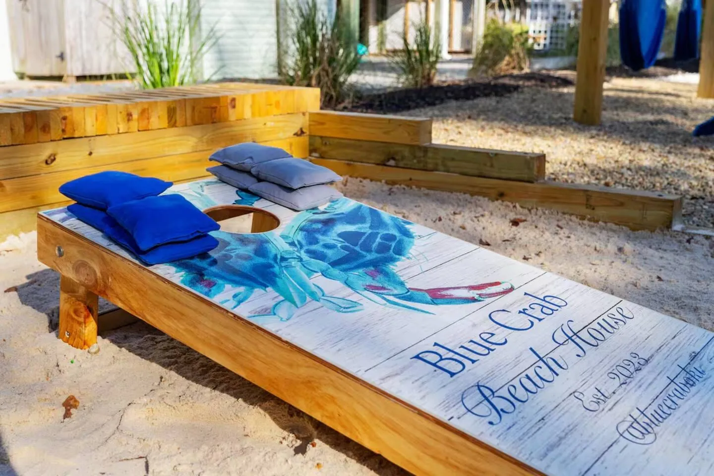 Close-up of a custom Blue Crab Beach House cornhole board with blue bean bags