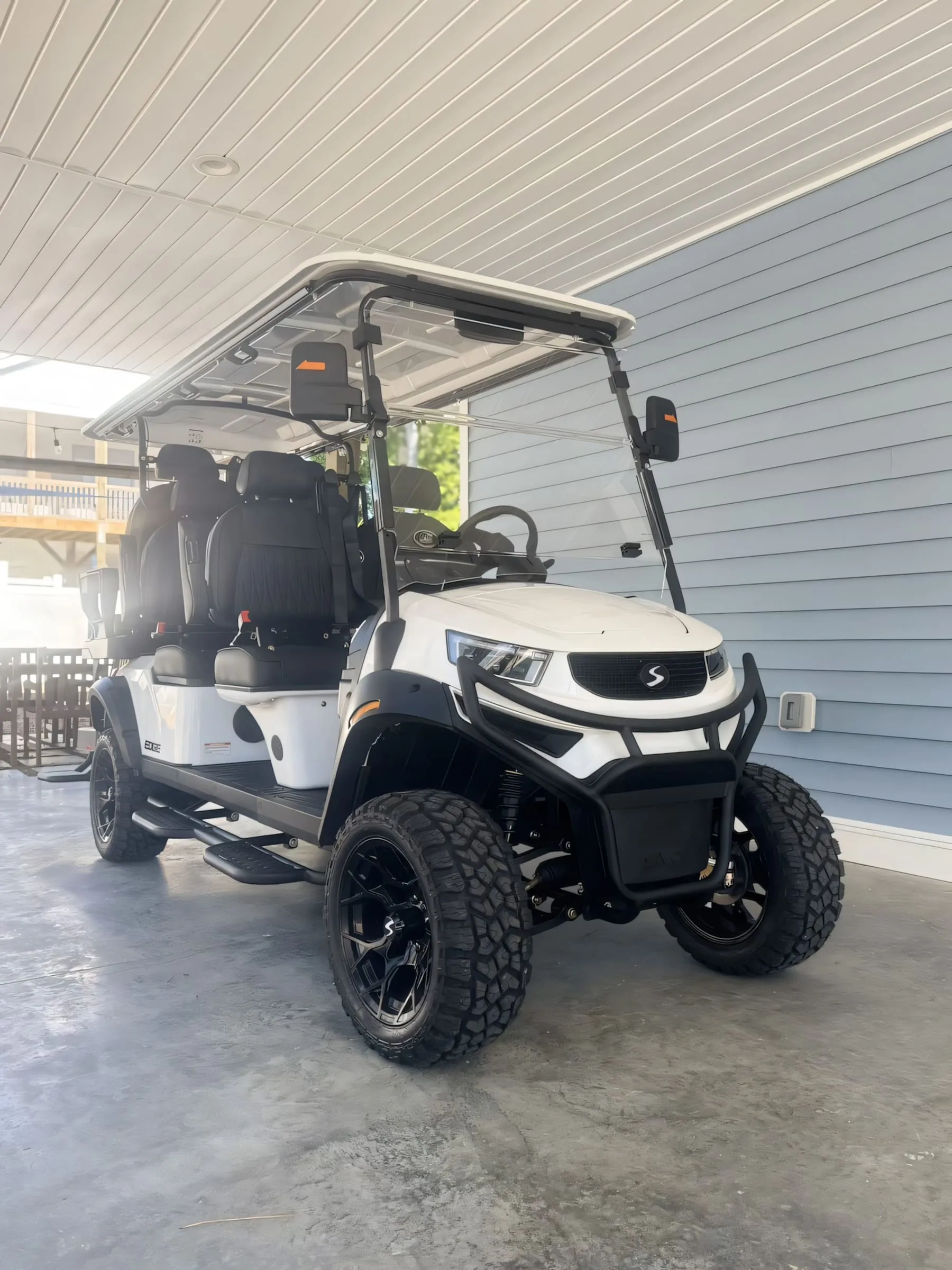 Front view of the six-seat golf cart parked under the house